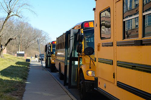 School busses by curb with doors open.