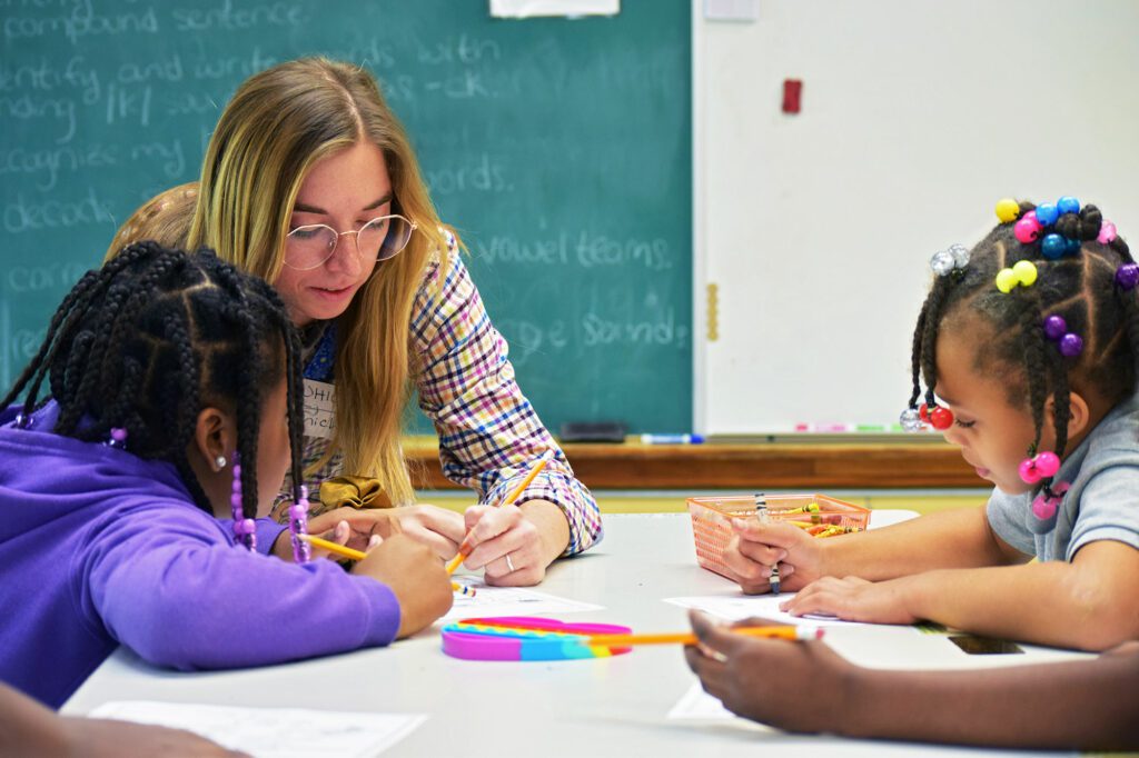 Teacher helping elementary students with their activity in a classroom.